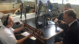 Huntington (W.Va.) Mayor Steve Williams (center) presents Jack Bogaczyk (left) with signage denoting that a traffic light on Third Avenue – adjacent to the Marshall University campus – was named in Bogaczyk’s honor on June 22, 2016. At right is Paul Swann, host of First Sentry Bank Sportsline on Huntington’s WRVC, where Bogaczyk was a Wednesday regular.